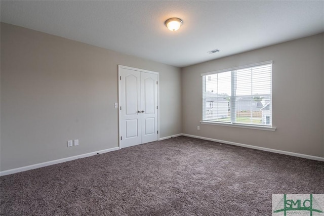 unfurnished room with carpet flooring and baseboards