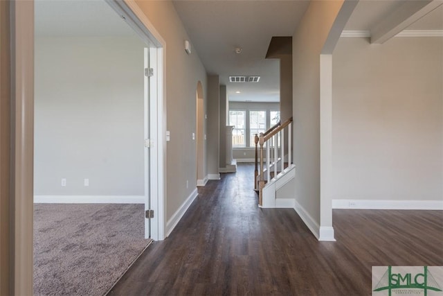 hall with baseboards, arched walkways, visible vents, dark wood-type flooring, and stairs