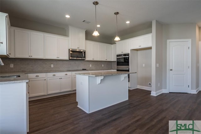 kitchen featuring visible vents, white cabinets, dark wood-style floors, stainless steel appliances, and a sink