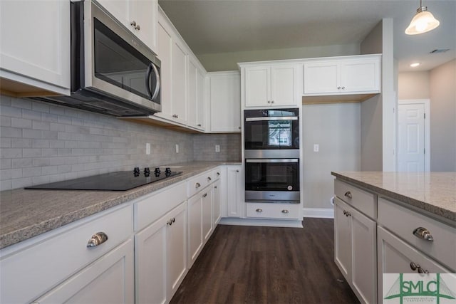 kitchen featuring light stone counters, stainless steel appliances, visible vents, dark wood-type flooring, and white cabinetry