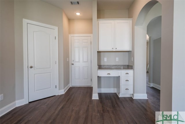 kitchen with dark wood finished floors, light countertops, visible vents, white cabinets, and baseboards