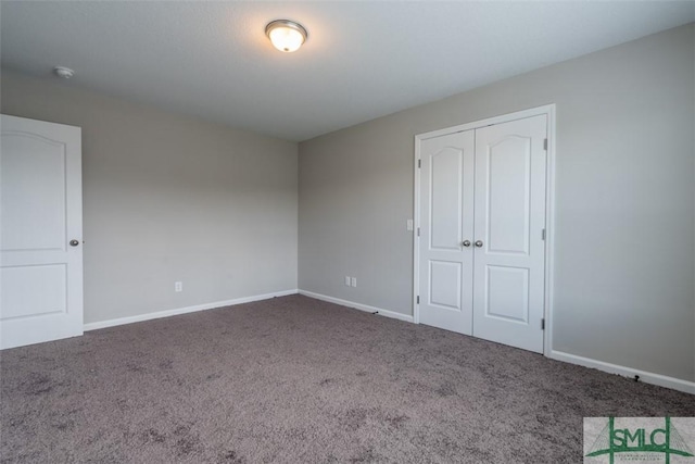 unfurnished bedroom with carpet floors, a closet, and baseboards