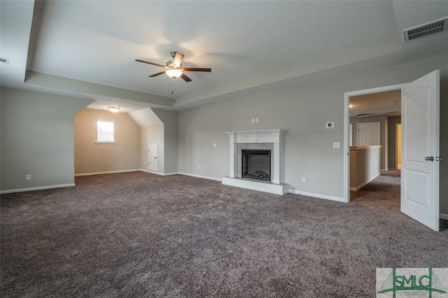 unfurnished living room with carpet floors, a high end fireplace, visible vents, and baseboards