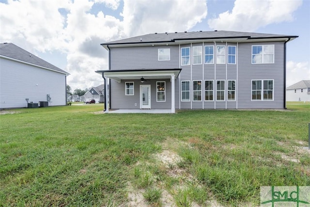 back of property with central air condition unit, a ceiling fan, a lawn, and a patio