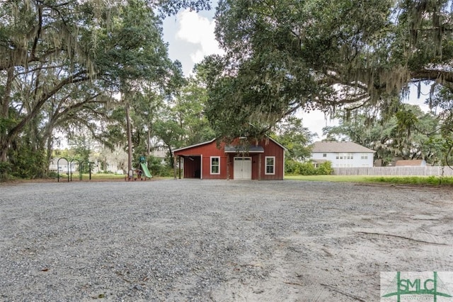 exterior space with an outbuilding, driveway, and fence