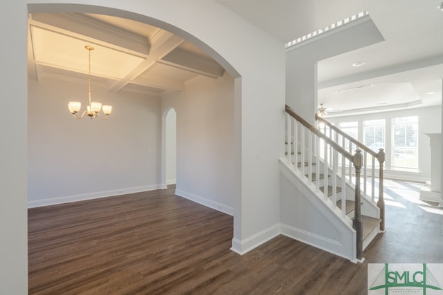 staircase featuring beam ceiling, coffered ceiling, hardwood / wood-style floors, and ceiling fan with notable chandelier