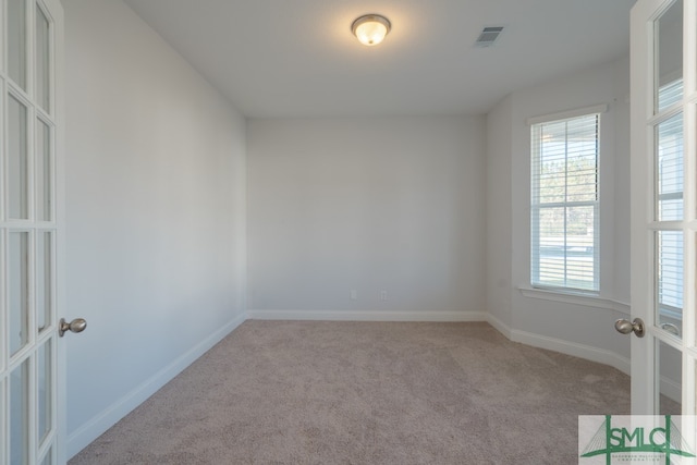 empty room with light colored carpet and french doors