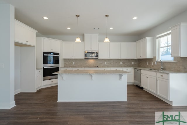 kitchen featuring dark hardwood / wood-style flooring, a center island, white cabinets, and stainless steel appliances