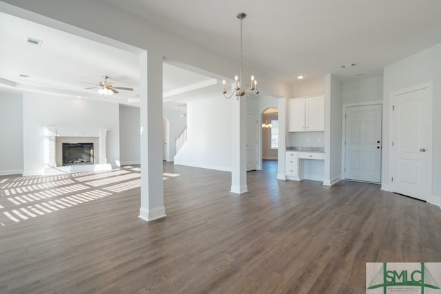 unfurnished living room with dark hardwood / wood-style floors and ceiling fan with notable chandelier