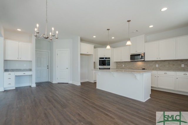 kitchen with a center island, white cabinets, dark hardwood / wood-style floors, and appliances with stainless steel finishes