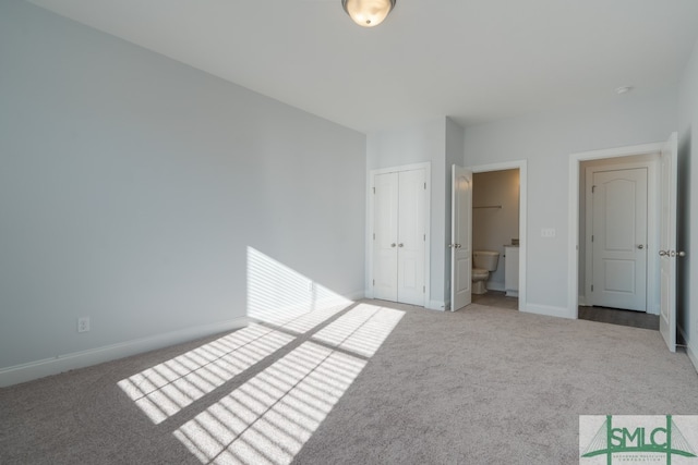 unfurnished bedroom with connected bathroom, carpet floors, and a closet