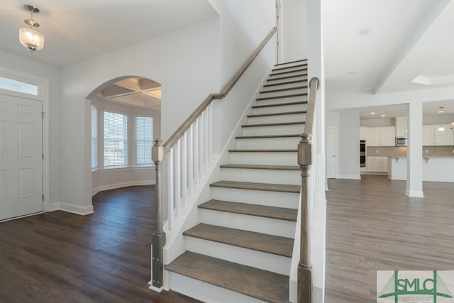 foyer entrance featuring beamed ceiling, dark hardwood / wood-style flooring, and coffered ceiling