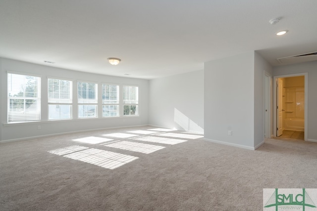 unfurnished room with light carpet and plenty of natural light