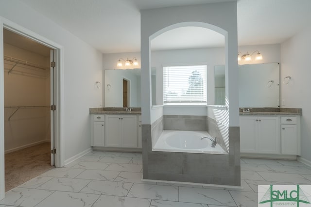 bathroom with vanity and a relaxing tiled tub