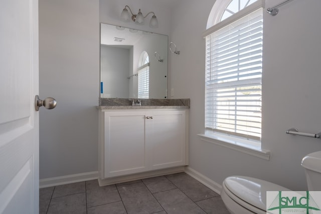 bathroom featuring tile patterned flooring, vanity, and toilet