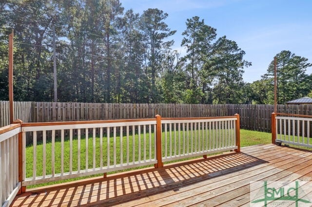 wooden deck featuring a lawn