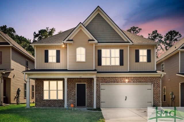 view of front of home with a garage and a lawn