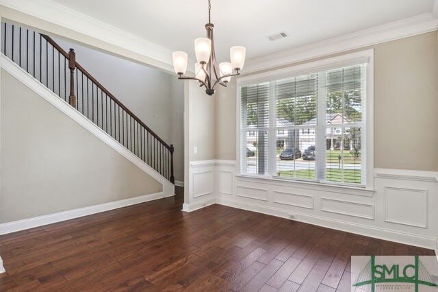 foyer entrance featuring crown molding, an inviting chandelier, and dark hardwood / wood-style floors