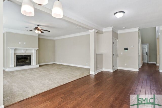 unfurnished living room featuring ceiling fan, dark hardwood / wood-style floors, and ornamental molding