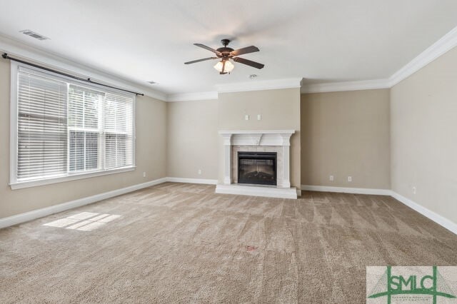 unfurnished living room with ceiling fan, a fireplace, carpet, and ornamental molding