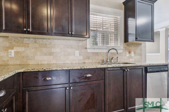 kitchen with stainless steel dishwasher, sink, light stone countertops, and backsplash