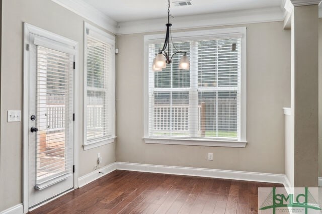 unfurnished dining area featuring dark wood-type flooring and a notable chandelier