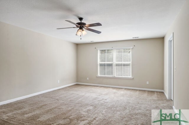 spare room featuring light colored carpet and ceiling fan