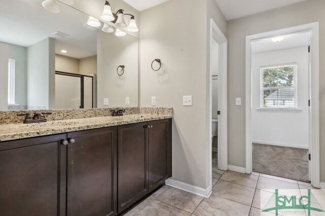 bathroom featuring tile patterned floors, a shower with shower door, toilet, and vanity