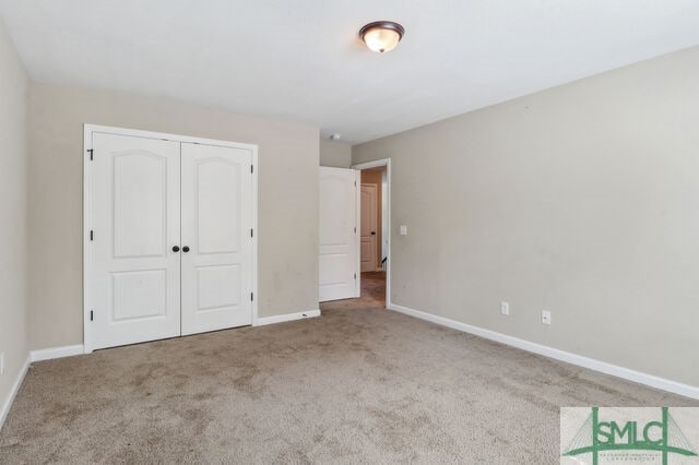 unfurnished bedroom with a closet and carpet floors