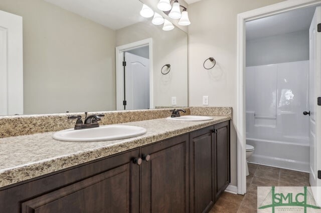 full bathroom featuring tub / shower combination, vanity, toilet, and tile patterned floors