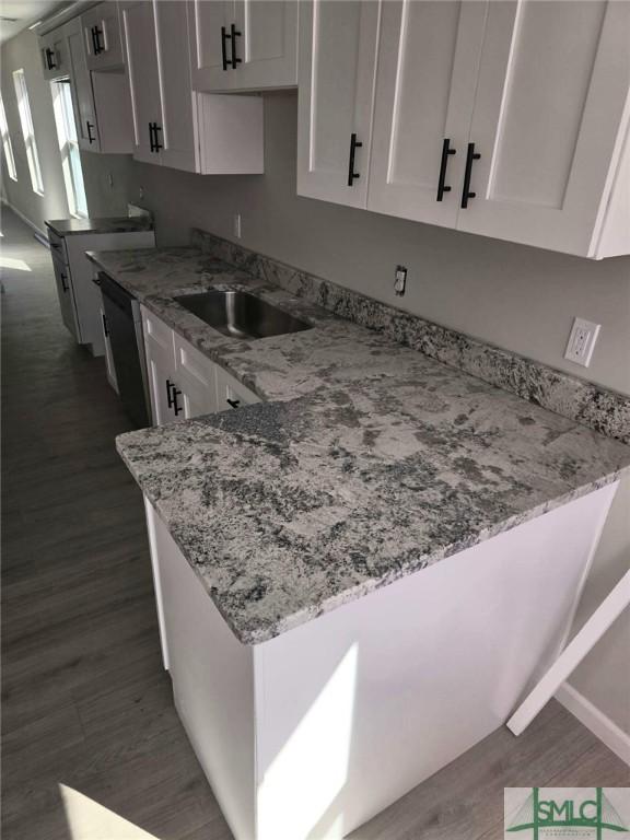 kitchen with white cabinetry, light stone countertops, and dark wood-type flooring