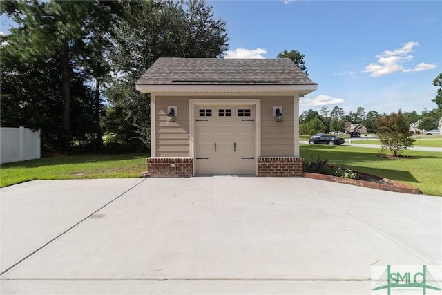 garage featuring driveway and fence