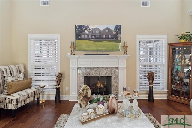 sitting room featuring a premium fireplace, plenty of natural light, and visible vents