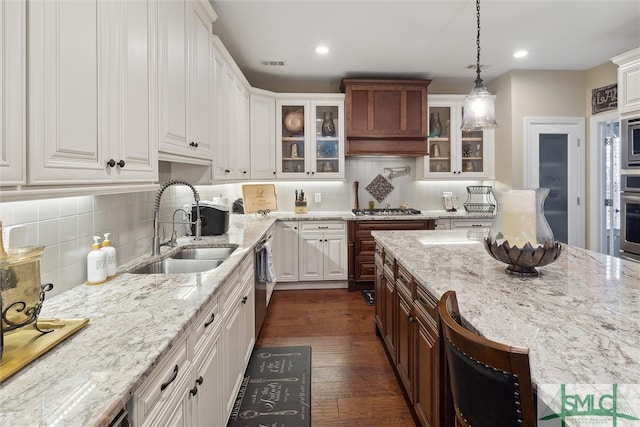 kitchen featuring glass insert cabinets, white cabinets, and a sink