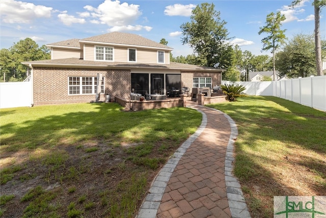 back of house with a yard, brick siding, a patio, and a fenced backyard