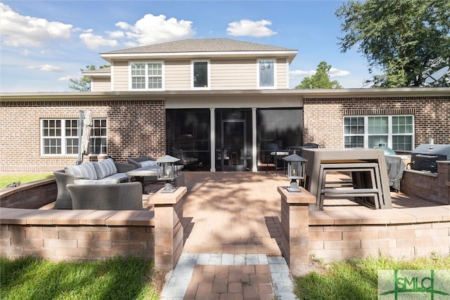 back of house with brick siding, a patio, and an outdoor living space