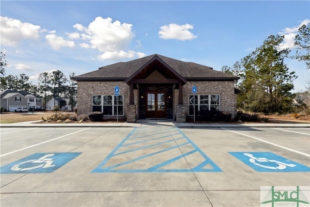 view of front of property featuring uncovered parking, french doors, and brick siding