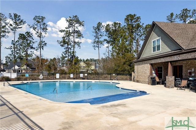 pool with a patio area and fence