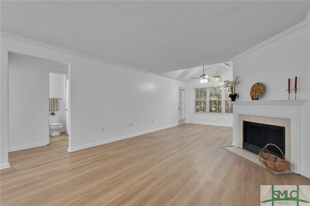 unfurnished living room with a textured ceiling, a fireplace, lofted ceiling, ceiling fan, and light wood-type flooring