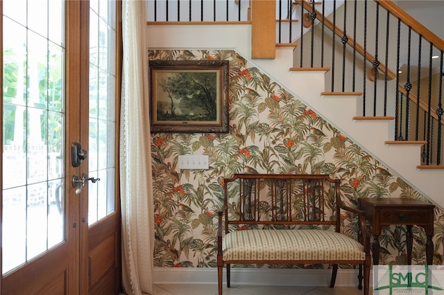 foyer featuring wallpapered walls, baseboards, stairway, and french doors