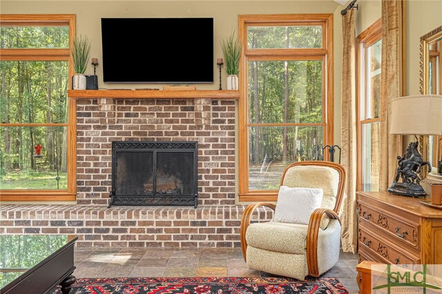 living room featuring a fireplace and a healthy amount of sunlight