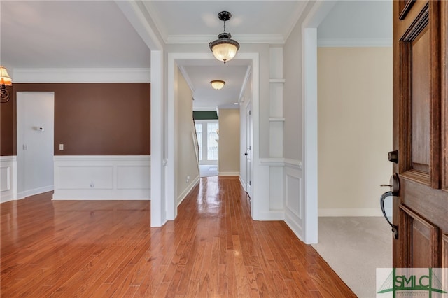 entryway with crown molding and light hardwood / wood-style flooring