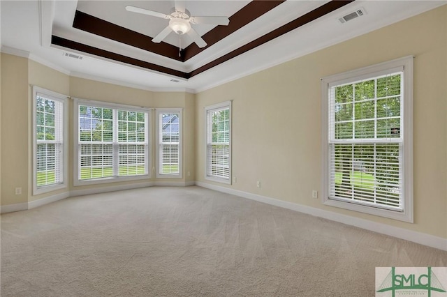 carpeted spare room with ornamental molding, ceiling fan, and a healthy amount of sunlight