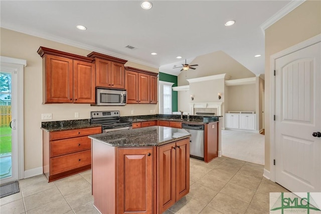 kitchen featuring ornamental molding, stainless steel appliances, ceiling fan, light tile patterned floors, and a kitchen island