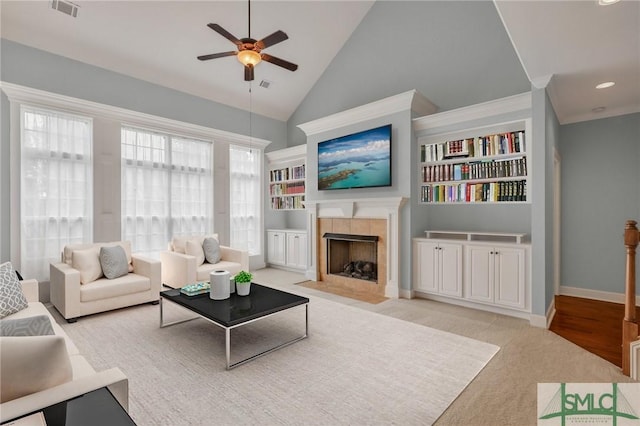 living room featuring ceiling fan, light hardwood / wood-style floors, a fireplace, and high vaulted ceiling