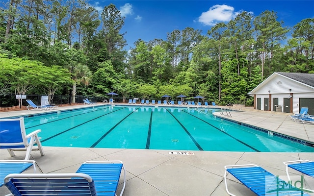 community pool featuring a patio and fence