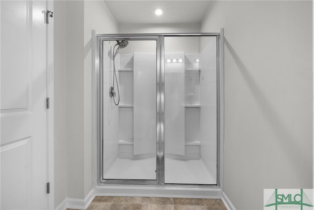 full bathroom with a stall shower and baseboards