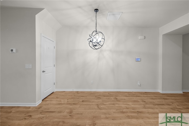 unfurnished dining area with light wood-style flooring, baseboards, and an inviting chandelier