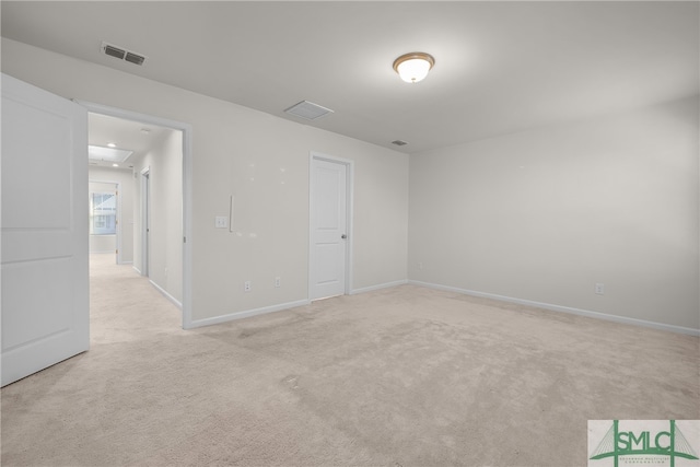 spare room featuring visible vents, light carpet, and baseboards