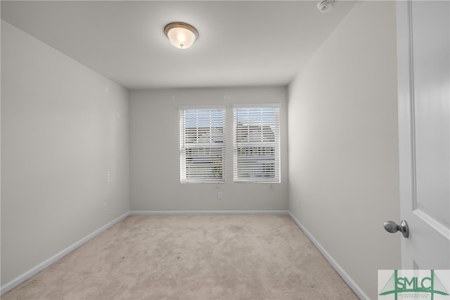 spare room with baseboards and carpet